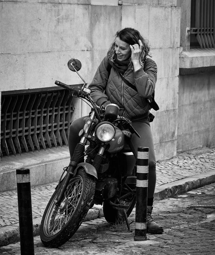 A woman on a motorcycle talking on the phone